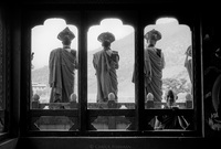 Buddhist monk musicians greet the monk king from Temple rooftop while he makes his way to his winter palace. Boy monk in foreground. Kingdom of Bhutan. 2004
